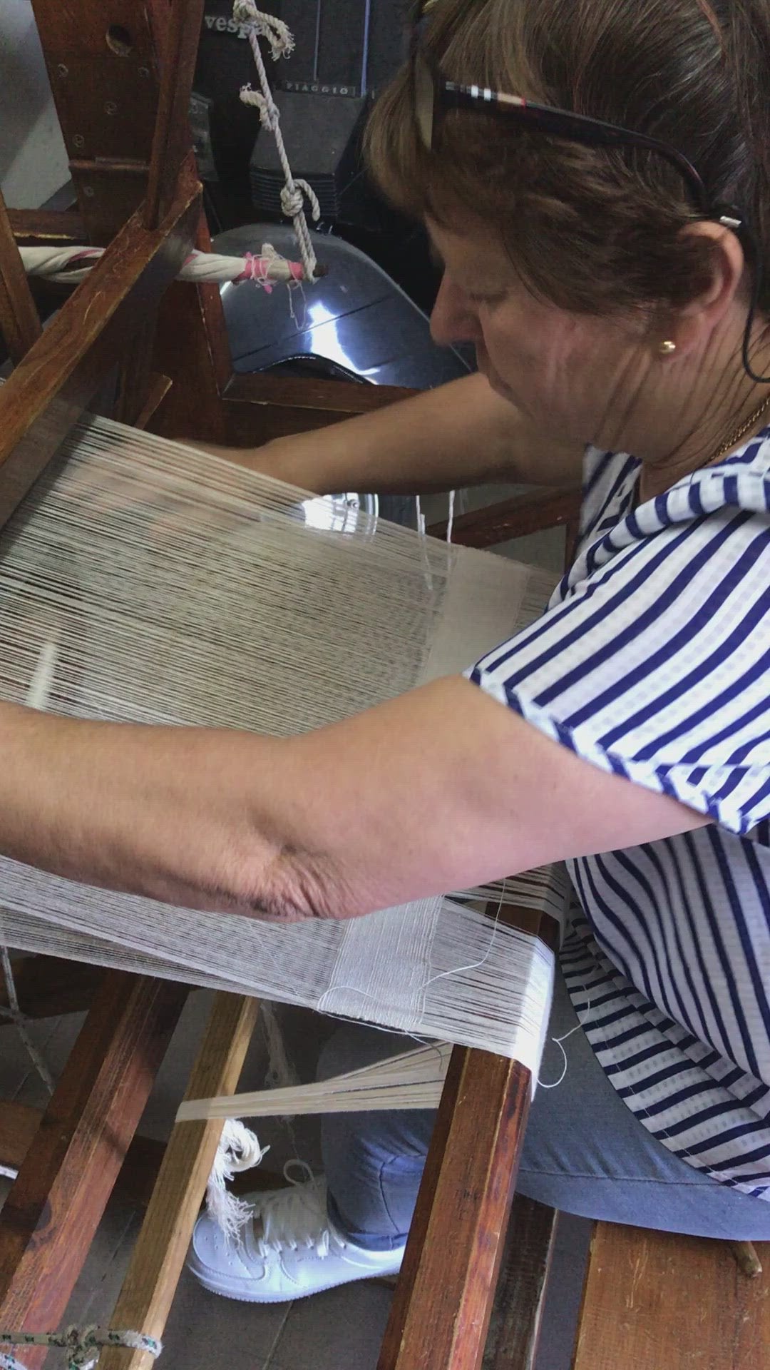 Portuguese lady operating a manual wooden loom