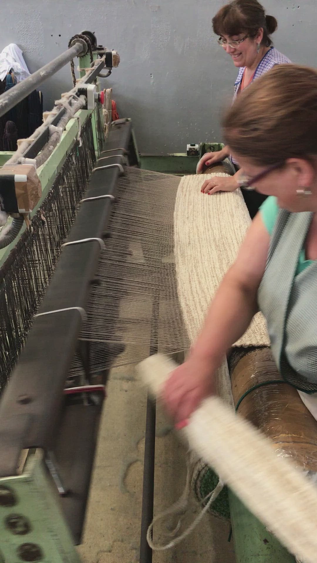 Two women working a part-mechanised, part-manual loom