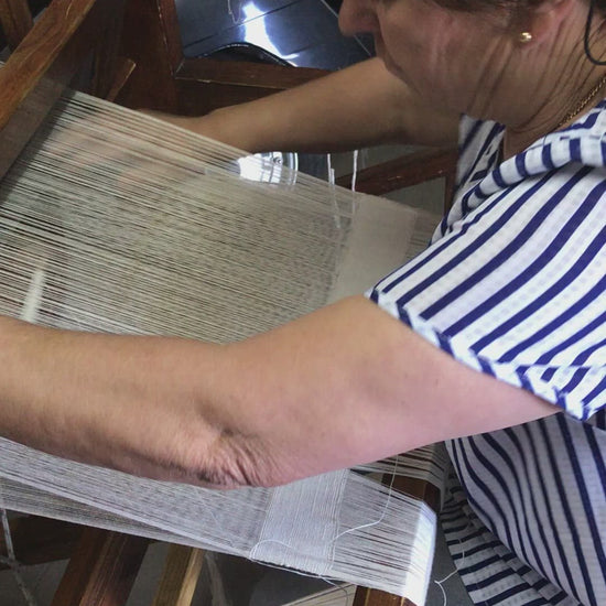 Portuguese lady operating a manual wooden loom